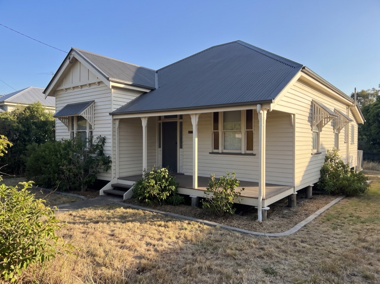 After: the same Queenslander home with new roof sheeting installed, site cleared